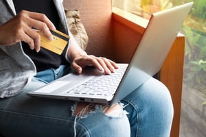 Man holding credit card while on laptop